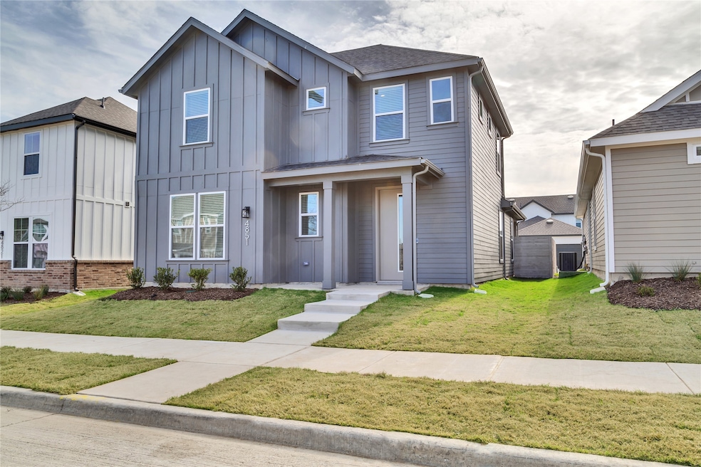 View of front of property with board and batten siding, roof with shingles, and a front lawn