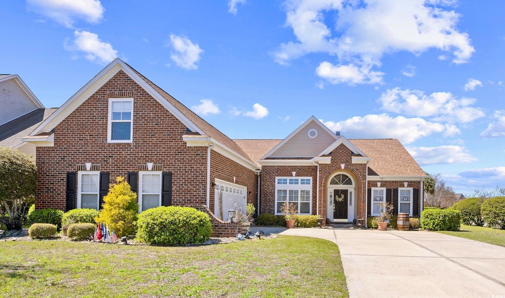 Traditional home with driveway, a front yard, bric