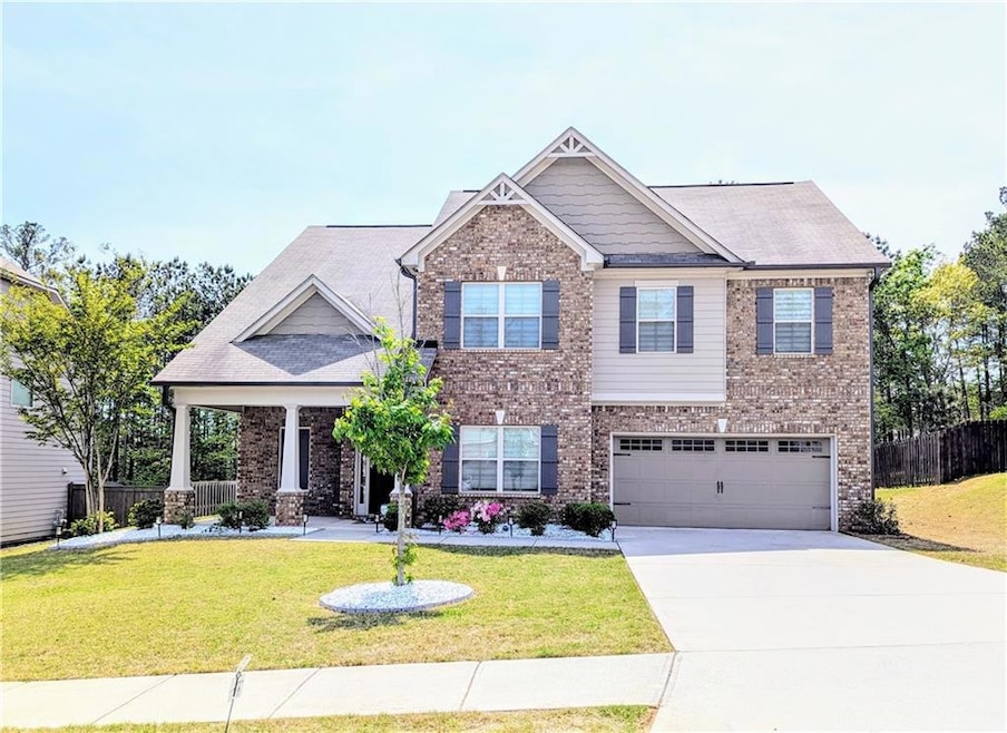 Craftsman-style house featuring brick siding, a front yard, concrete driveway, and fence