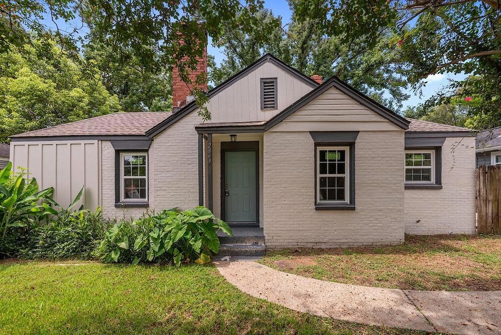 View of front of property featuring a chimney, brick siding, and a shingled roof