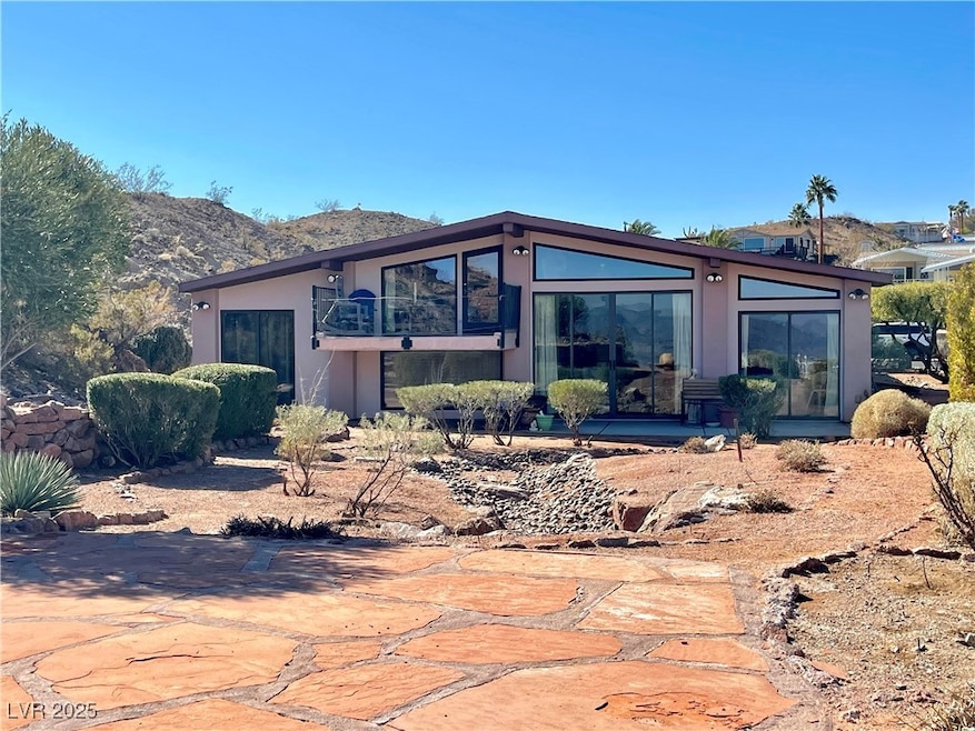 Back of property with stucco siding, a balcony, an