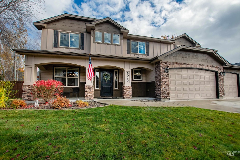 Craftsman inspired home featuring stone siding, covered porch, a front lawn, and an attached garage