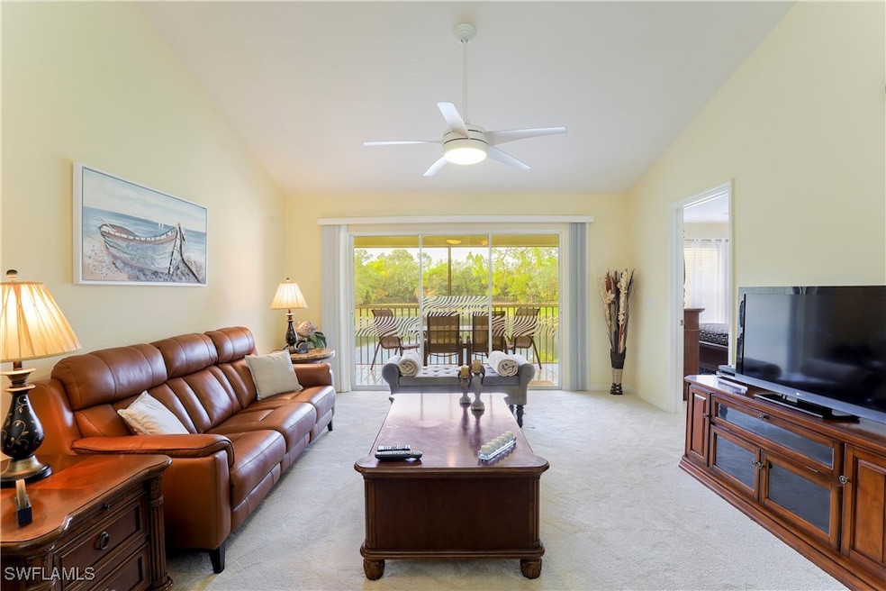 Carpeted living room with vaulted ceiling and ceil