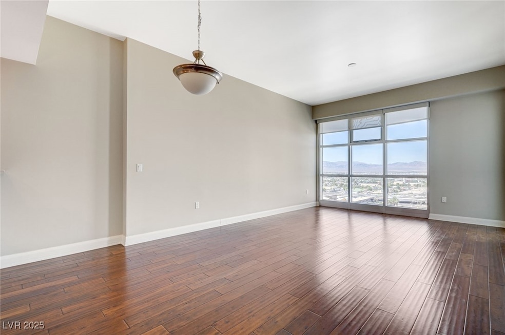 Spare room featuring dark wood-type flooring and a mountain view