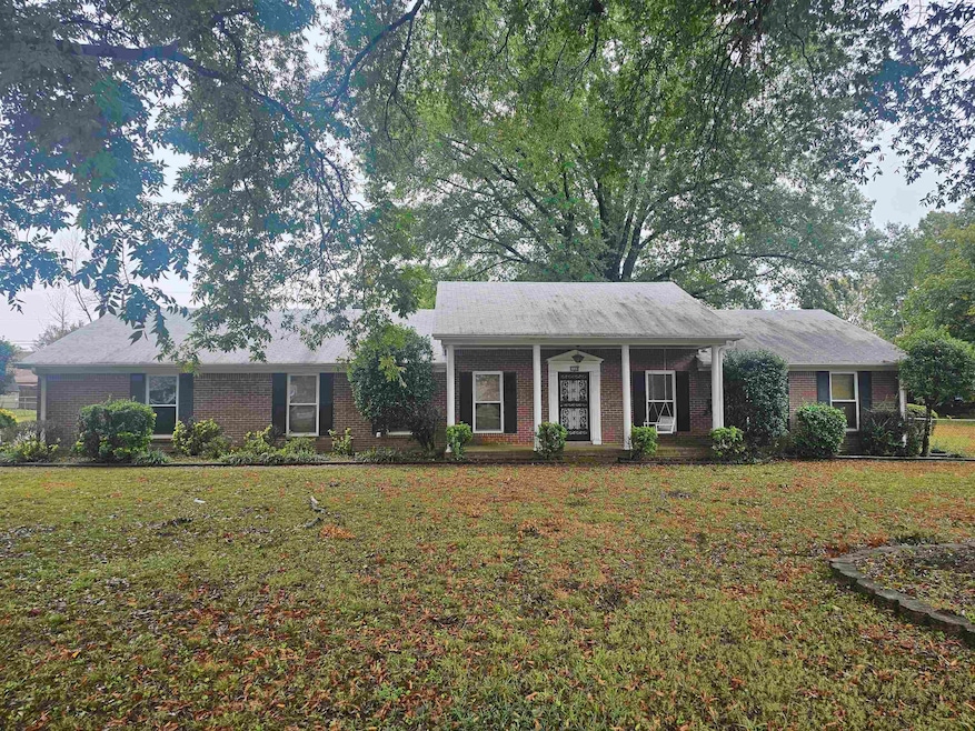 Ranch-style house featuring a porch and a front la