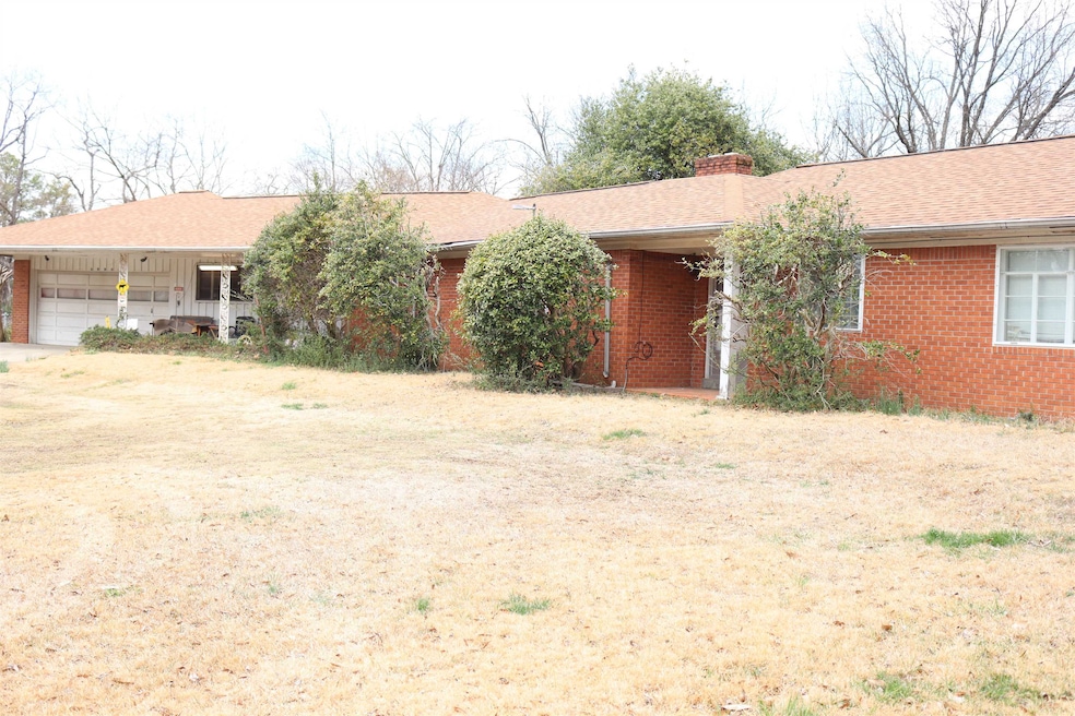Ranch-style home featuring a shingled roof, brick 