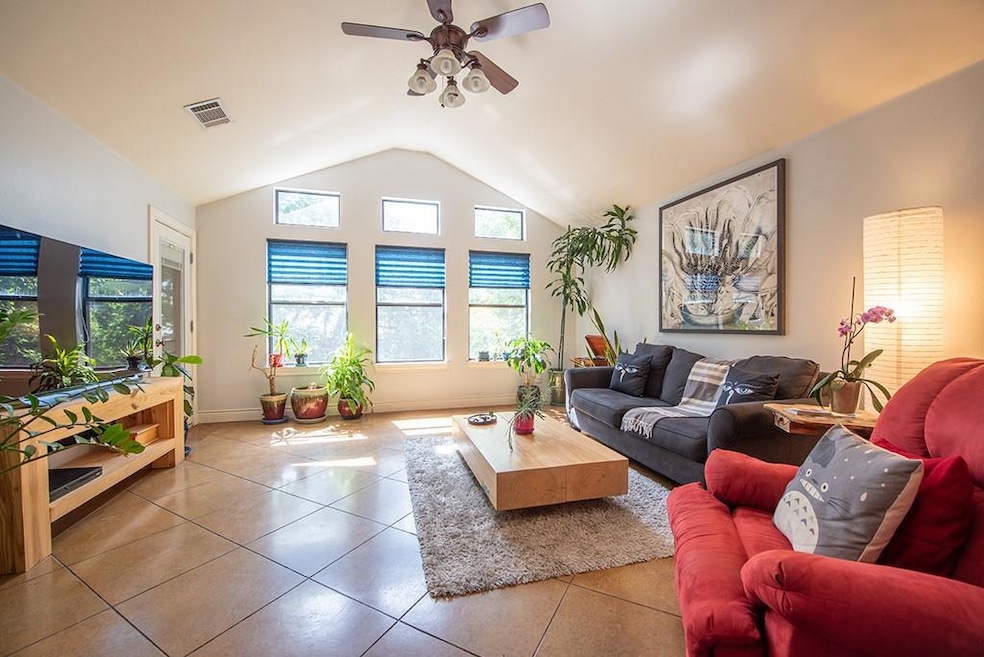 Tiled living room featuring ceiling fan and lofte