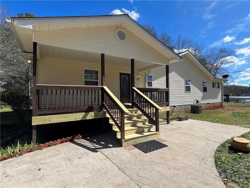 View of front of home with central AC and covered 