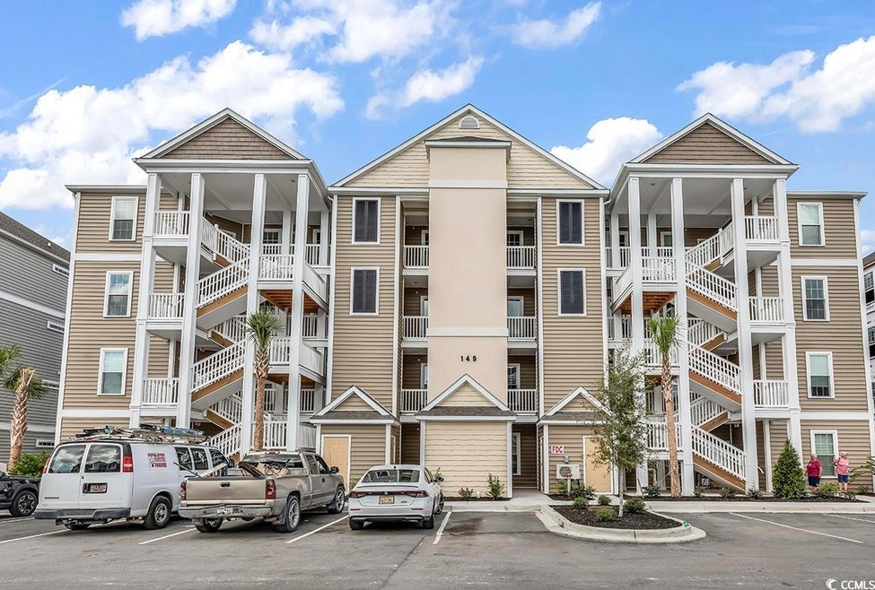 View of apartment building / complex with uncovered parking