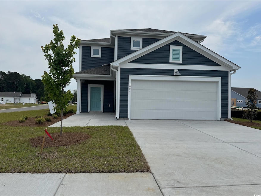 Traditional home featuring concrete driveway, a garage, a front yard, and a shingled roof