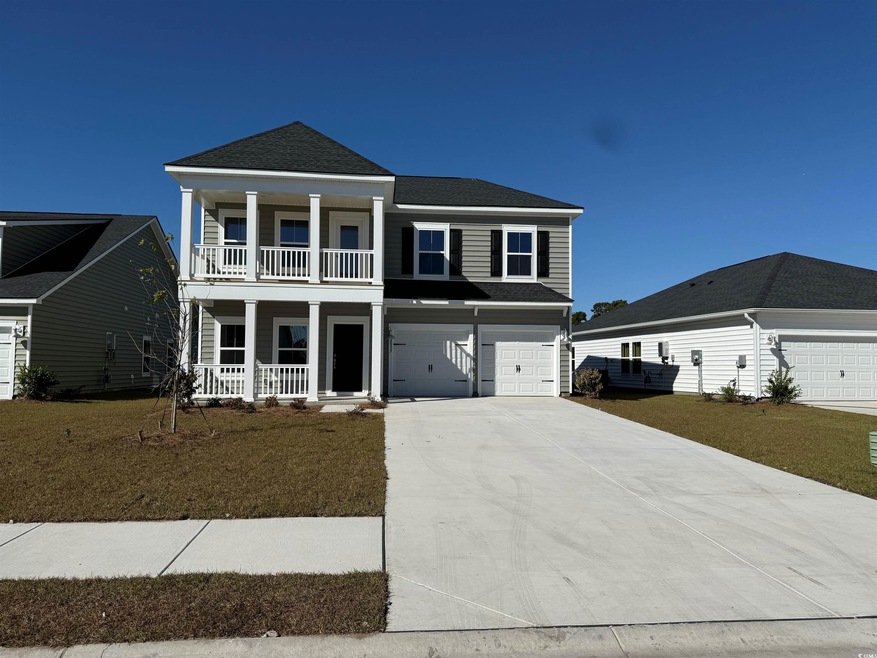 View of front of property with a front lawn, a gar