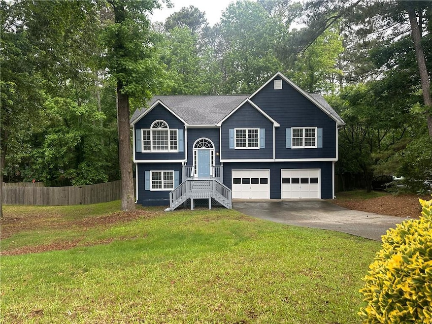 Raised ranch featuring an attached garage, drivewa