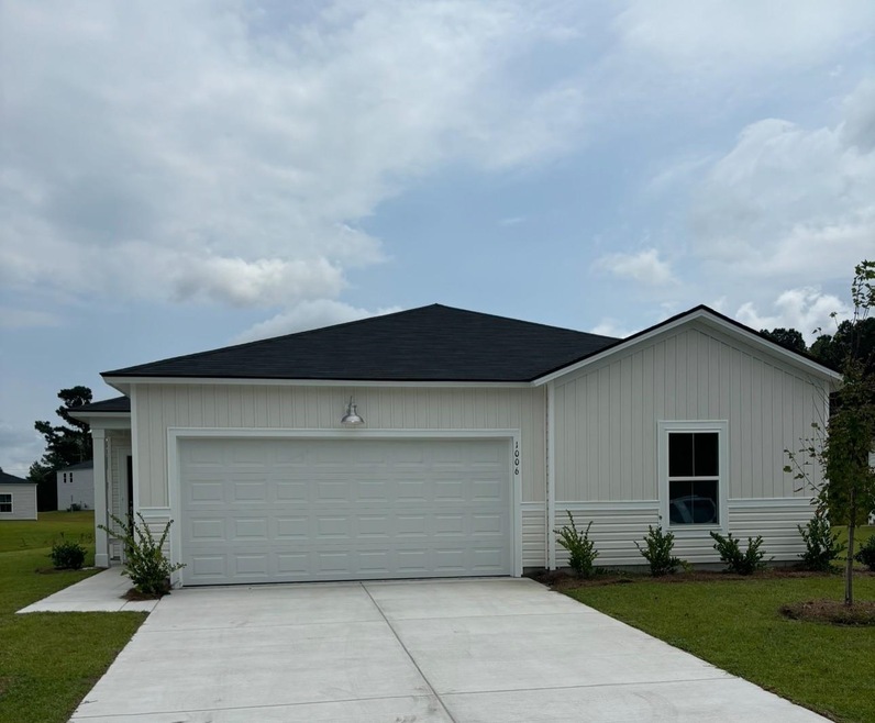 View of front of house with a garage and a front y