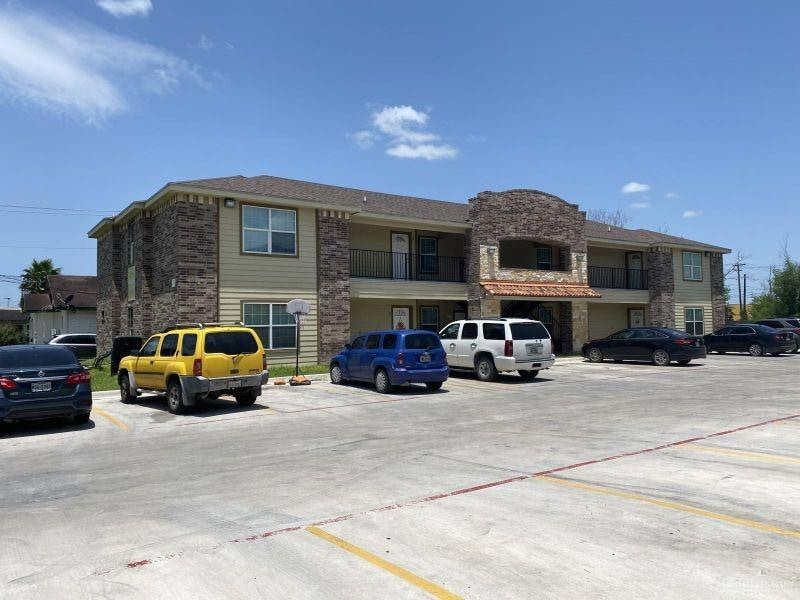 View of building exterior with uncovered parking