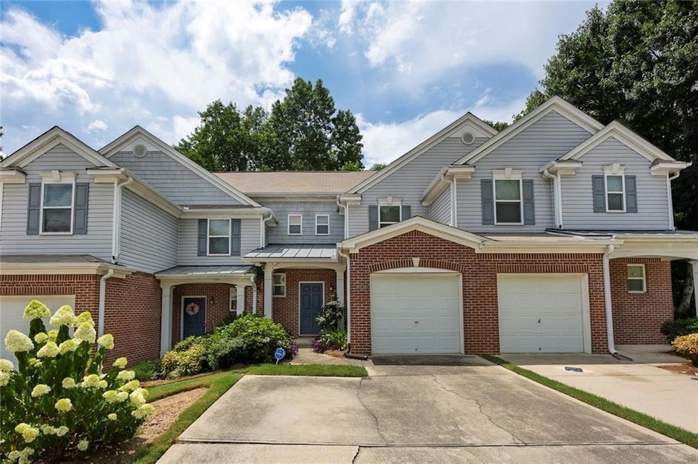View of front of home with concrete driveway, brick siding, and an attached garage