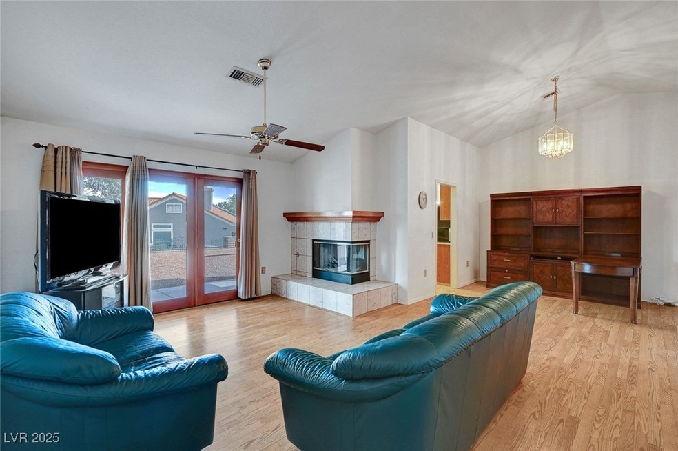 Living room featuring vaulted ceiling, a tiled fir