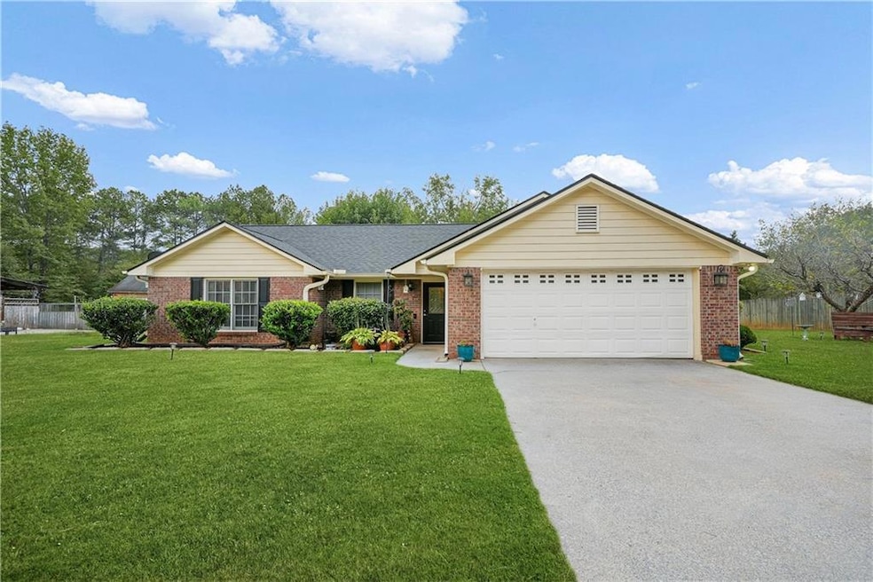 Ranch-style house featuring driveway, brick siding, and a garage