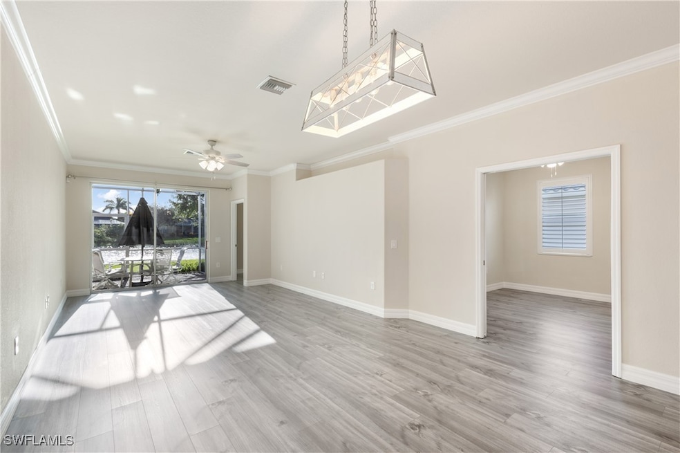 Open living room featuring crown molding, wood finished floors, and a ceiling fan