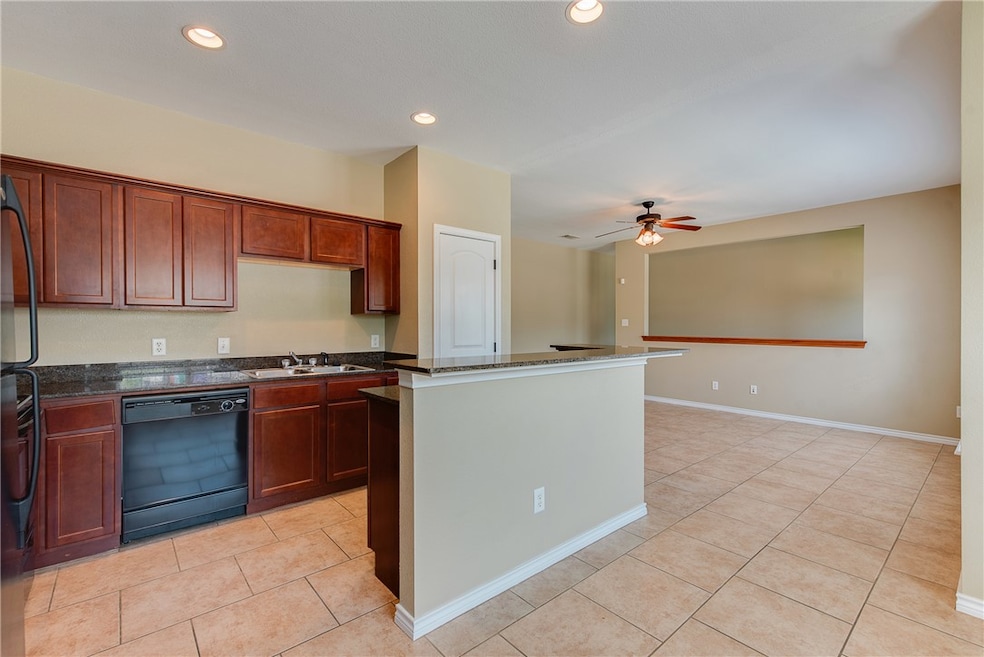 Kitchen featuring black dishwasher, light tile pat