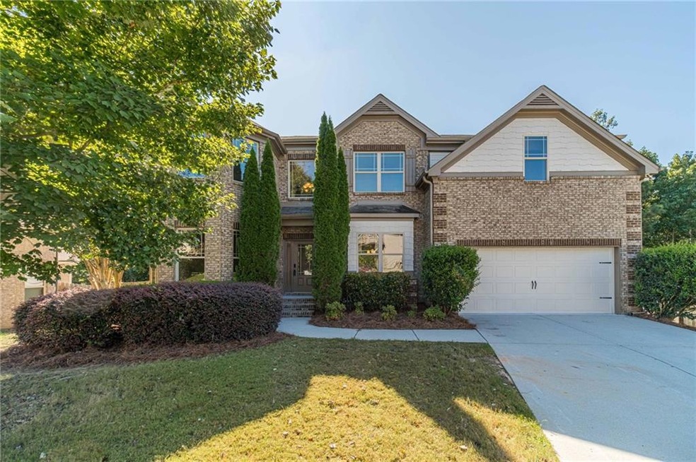 Craftsman-style home featuring concrete driveway, brick siding, a front yard, and a garage
