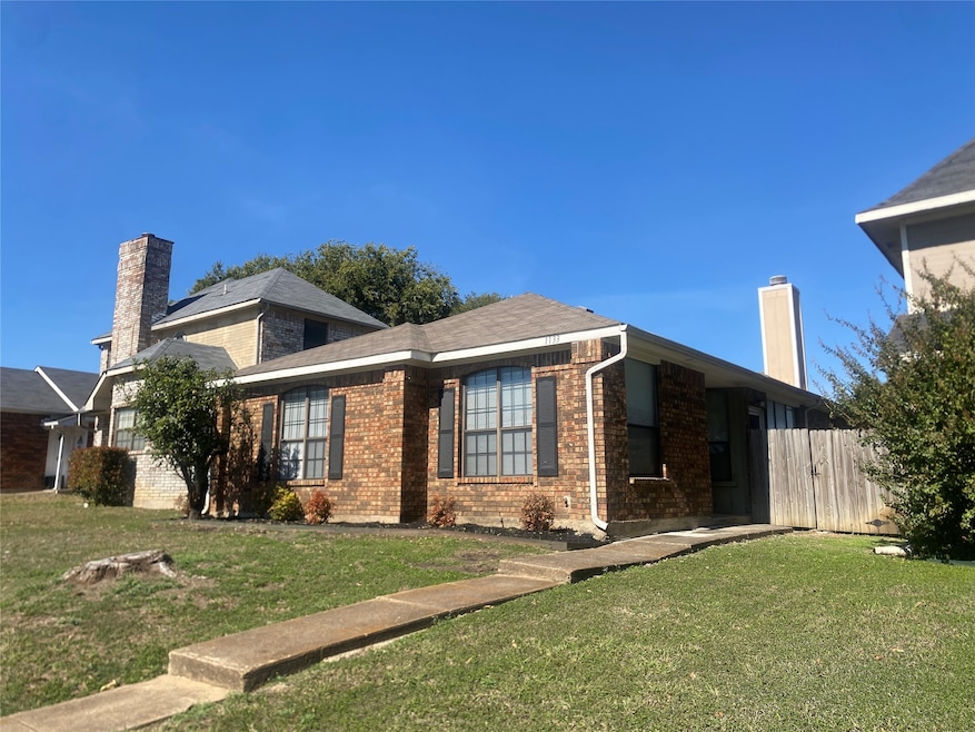 View of front facade with brick siding and a chimney