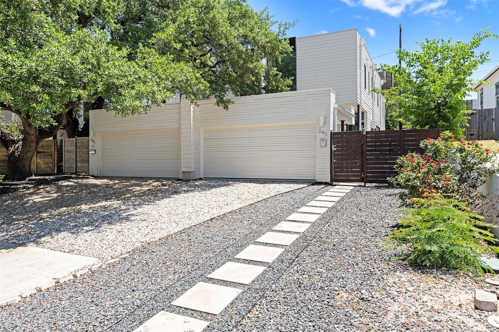 Garage featuring a gate, fence, and driveway