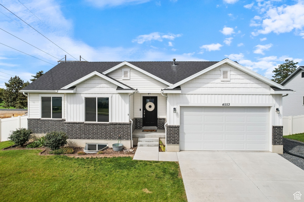 View of front of property featuring board and batten siding, concrete driveway, an attached garage, and roof with shingles