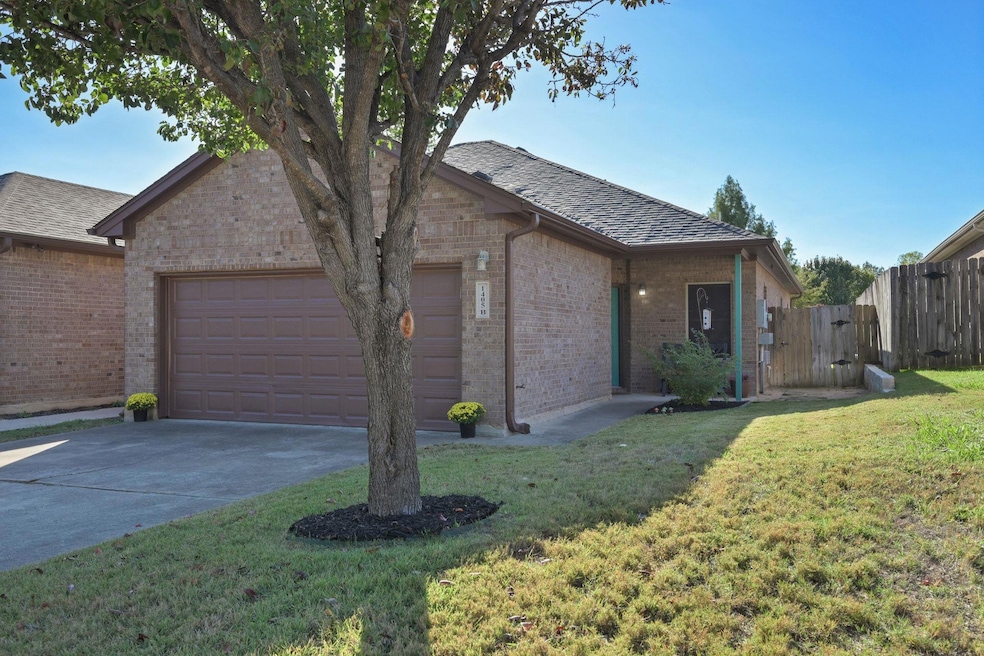 View of front of home featuring brick siding, roof with shingles, and concrete driveway