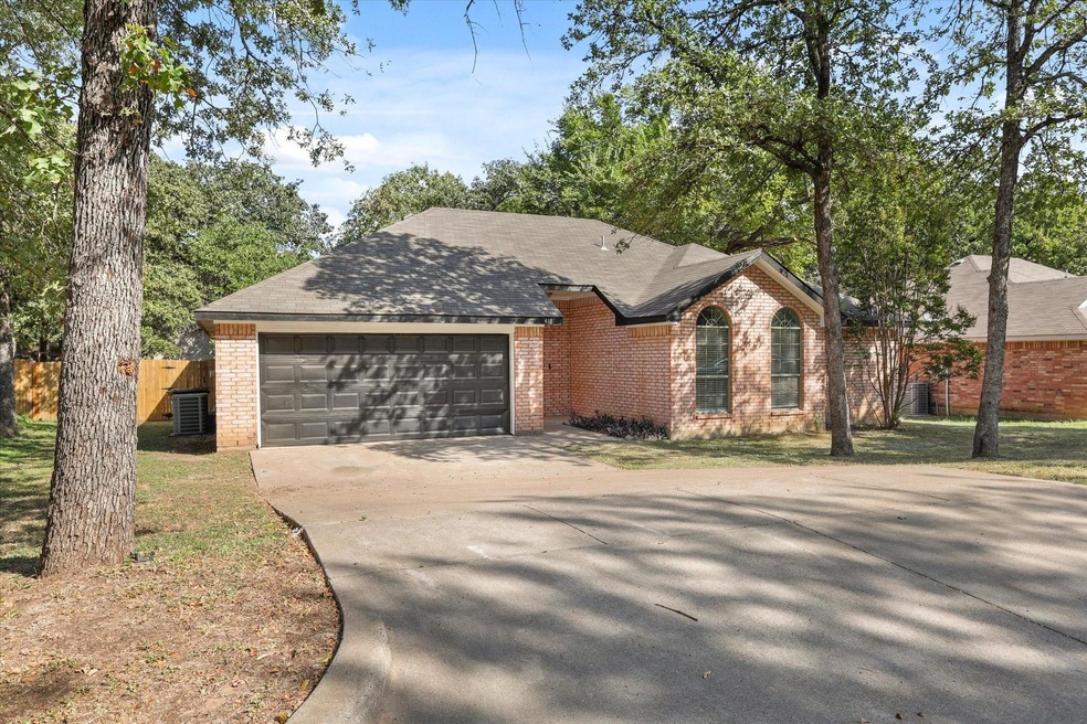 Ranch-style home with a garage, brick siding, conc