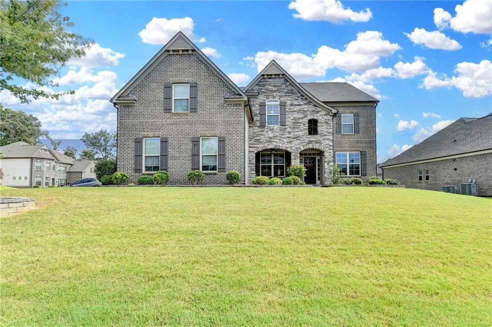 French country inspired facade featuring a front lawn and brick siding