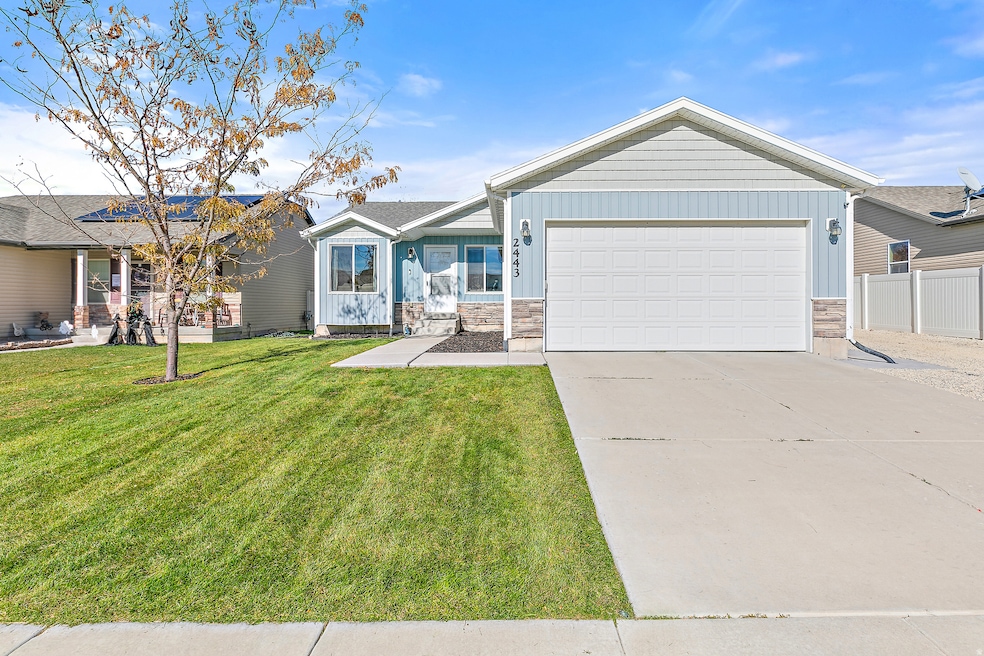 Ranch-style home with board and batten siding, stone siding, concrete driveway, and a garage