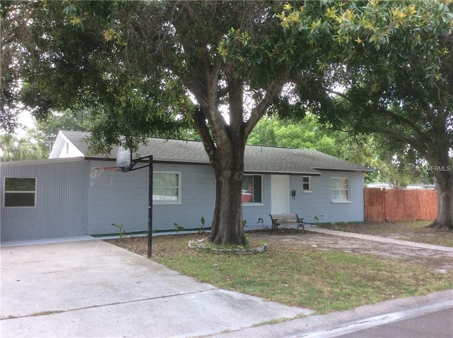 Block home with established trees in front