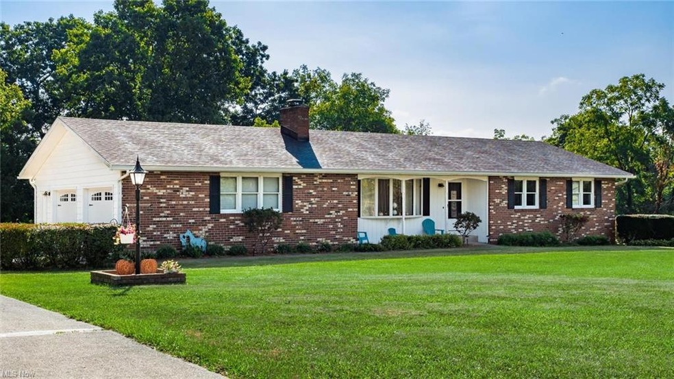 Ranch-style house featuring a front yard and garage