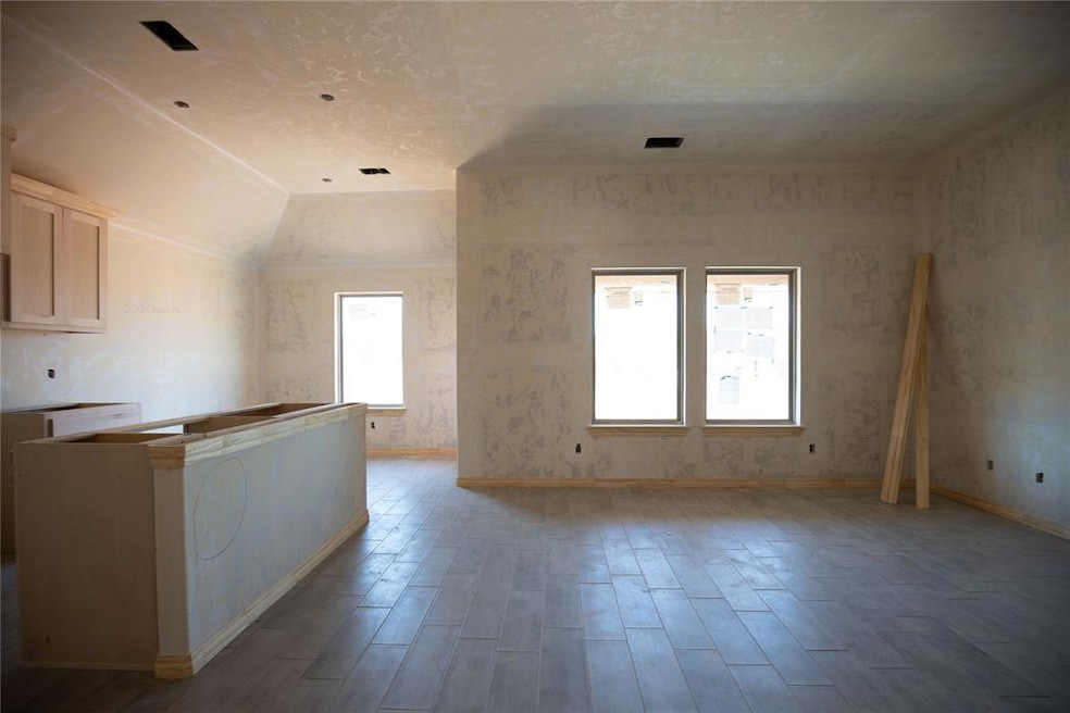 Spare room with vaulted ceiling, light wood-type f