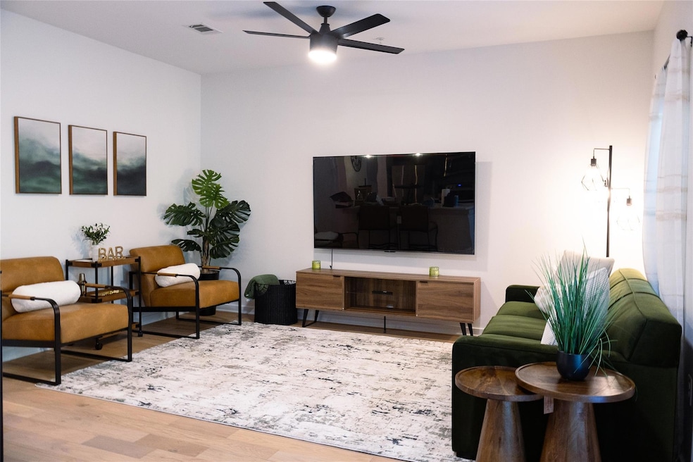 Living area featuring wood finished floors and ceiling fan