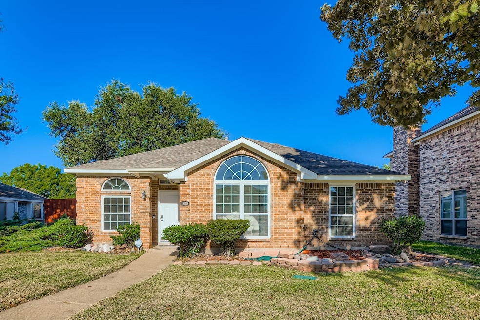 Ranch-style house with a front lawn, roof with shingles, and brick siding