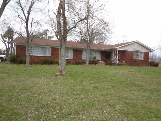 View of the home from the front yard standing near the fence that surrounds the yard.