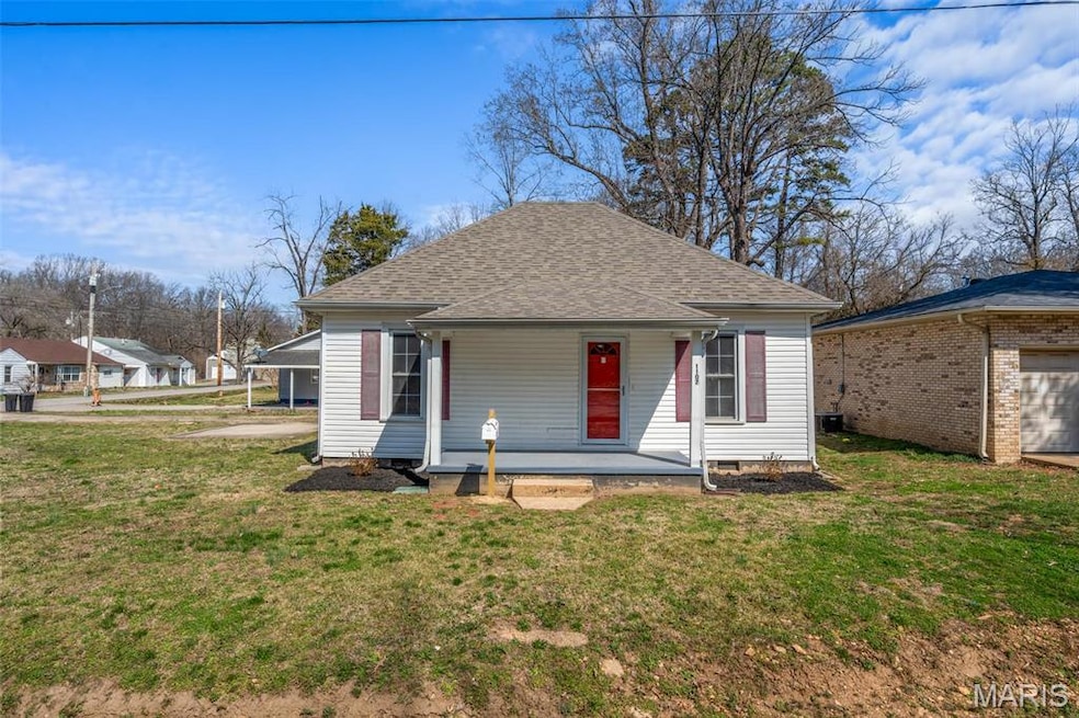 View of front of house featuring a front yard, a porch, and roof with shingles