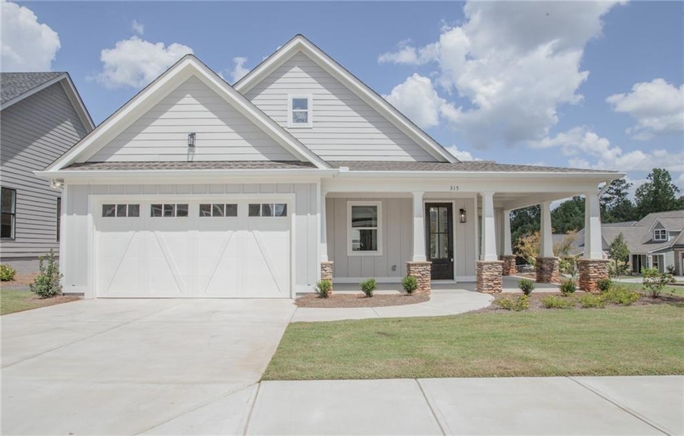 View of front of house with a porch, a garage, and