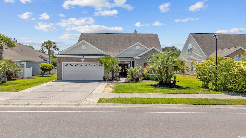 View of front of home featuring an attached garage, a front lawn, brick siding, and driveway
