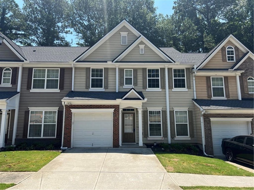 View of front facade with a garage and a front law