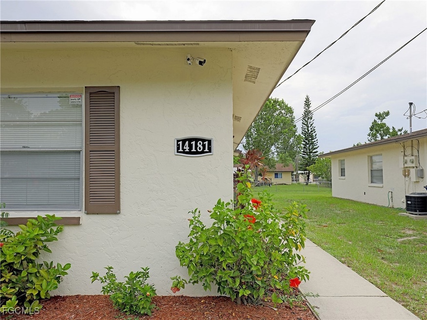 Doorway to property featuring a lawn and stucco siding