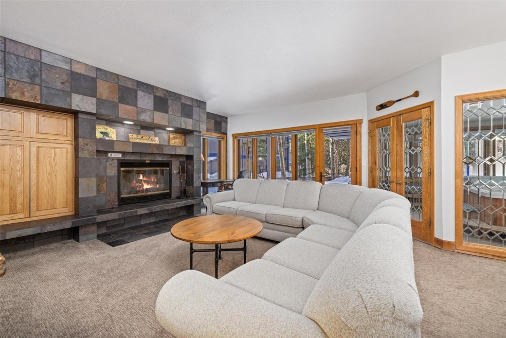 Carpeted living room with a tiled fireplace
