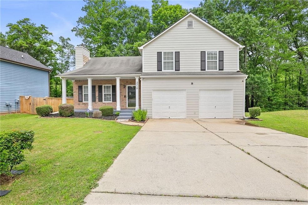 View of front of house with a porch, a garage, driveway, a chimney, and brick siding