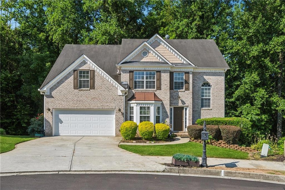 View of front of property featuring driveway and brick siding
