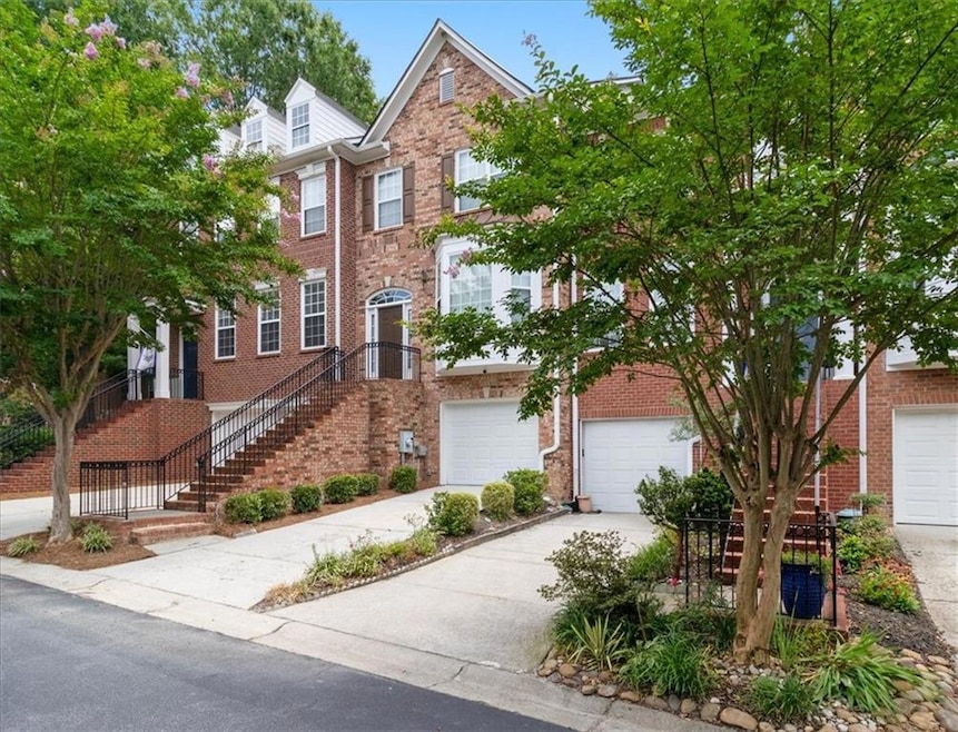Multi unit property featuring brick siding, concrete driveway, and a garage