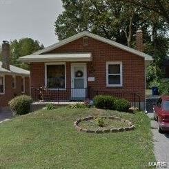 Bungalow-style home with covered porch, a front lawn, and a chimney