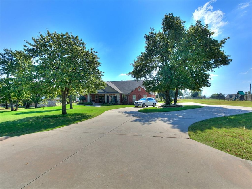 View of front of property featuring curved driveway and a front lawn