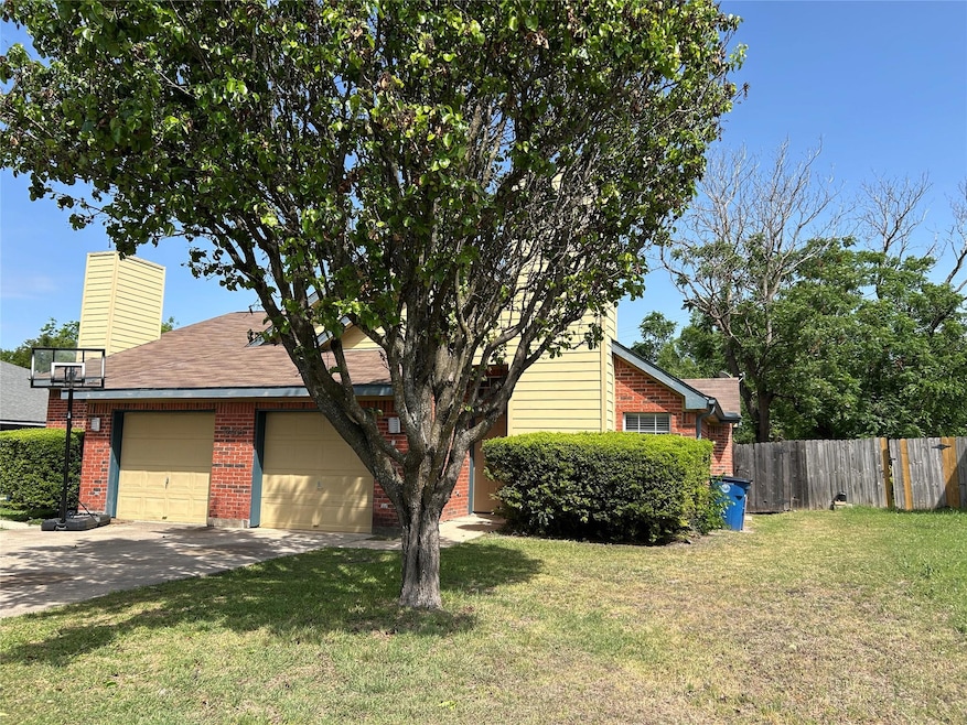 View of front of home with brick siding, fence, a