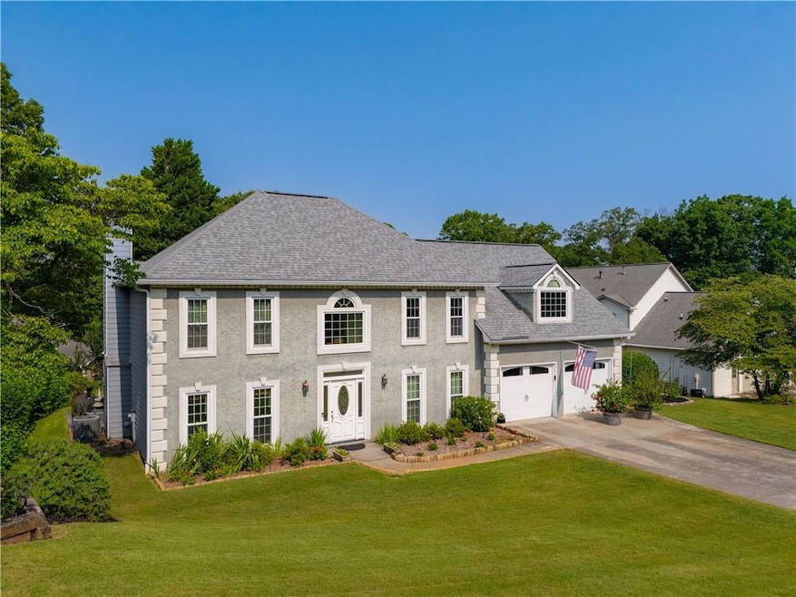 View of front of home featuring concrete driveway, a front yard, and roof with shingles